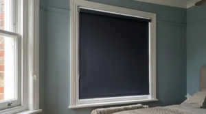 Close-up of blackout thermal roller blinds installed in a bedroom for improved insulation and privacy.
