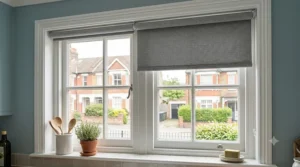 Stylish grey thermal roller blinds fitted on a kitchen window, providing heat control and moisture resistance.