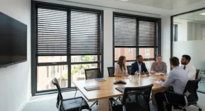 Stylish black aluminium venetian blinds fitted in a contemporary boardroom for glare reduction.