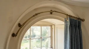 Close-up of a curtain track vs curtain pole installation in a curved bay window.